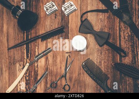 Friseurwerkzeuge. Draufsicht auf Friseurwerkzeuge und Herrenzubehör, die auf der Holzmaserung liegen Stockfoto