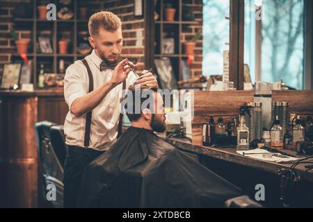 Das Haar sieht magisch aus. Junger bärtiger Mann, der beim Friseur im Stuhl sitzt Stockfoto