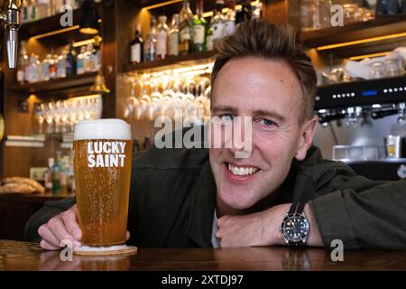 Luke Boase, Gründer und CEO der alkoholfreien Biermarke Lucky Saint, fotografierte mit seinem alkoholfreien Bier in einem Londoner Pub in England, Großbritannien Stockfoto