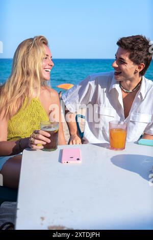 Glückliches junges Paar im Urlaub, trinkt im Restaurant. Vertikal Stockfoto