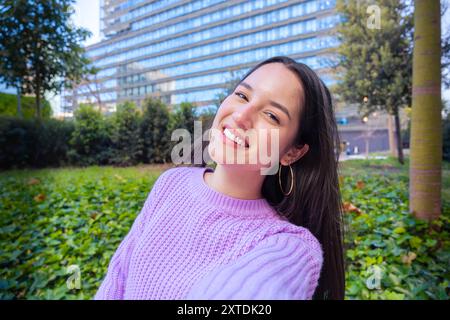 Junge lateinfrau, die selbstbewusst lächelnd auf der Straße steht Stockfoto
