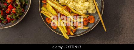 Genießen Sie ein köstliches vegetarisches Mittagessen oder Frühstück mit Hirse, gerösteter Zucchini und Karotten, einem frischen Salat mit saisonalem Gemüse und Kräutern, plus Stockfoto