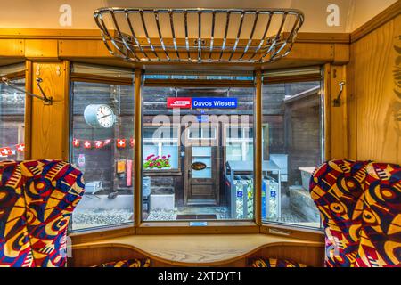 Luxuriöser Alpine Classic Pullman Express, erbaut 1931, auf nostalgischer Fahrt von Davos nach Andermatt, hier mit Blick auf den Bahnsteig im Dorf Wiesen im Kanton Graubünden. Alpine Classic Pullman Express auf der Route des Glacier Express. Die Höhe der Schlafgelegenheit über dem Meeresspiegel wird an jeder Station angezeigt. Graubünden, Schweiz Stockfoto