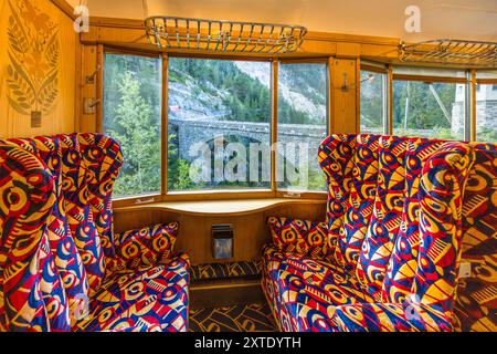 Alpine Classic Pullman Express-Wagen, 1931 gebaut, mit Paketregal, Holzvertäfelung und Intarsien des französischen Designers René PROU und Polsterung im Art déco-Stil auf einer nostalgischen Reise von Davos nach Andermatt, hier mit Blick auf ein Viadukt. Alpine Classic Pullman Express auf der Route des Glacier Express, Graubünden, Schweiz Stockfoto