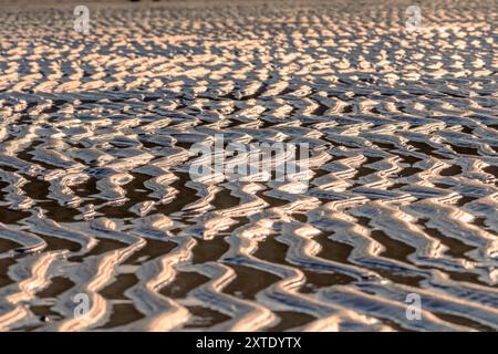 Bei Ebbe sind komplizierte Muster im Sand am Ardroil Beach zu erkennen, die das glitzernde Wasser auf der Isle of Lewis reflektieren. Stockfoto