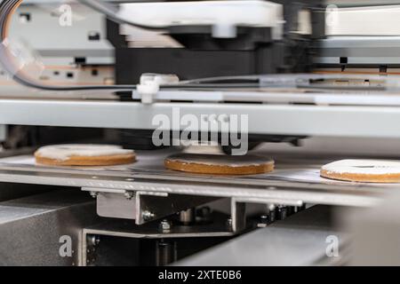 Ein Lebensmitteldrucker druckt Kekse mit Zuckerguss. Neue Technologien der Zukunft in der Lebensmittelproduktion. Hochwertige Fotos Stockfoto