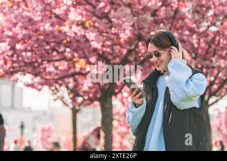 Musikliebhaberin, die Songs auf ihrem Handy überprüft Stockfoto