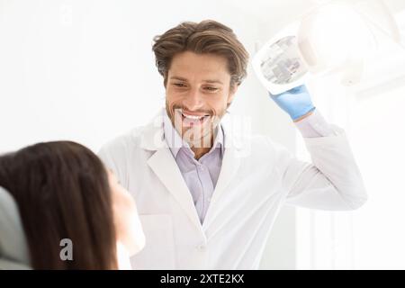 Fröhlicher junger Zahnarzt grüßt seine Patientin Stockfoto