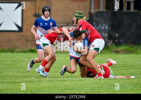 Neath, Wales. 3. August 2024. Bradley McDonough aus England Community Lions wird am 3. August 2024 von zwei walisischen Spielern während des U16 Four Nations Rugby League Championship-Spiels zwischen Wales und England Community Lions im Lextan Gnoll in Neath, Wales, Großbritannien, bekämpft. Quelle: Duncan Thomas/Majestic Media. Stockfoto