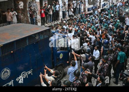 Die Menschen versammeln sich um ein Polizeifahrzeug mit dem ehemaligen Justizminister Anisul Huq und dem Berater des ehemaligen Premierministers Scheich Hasina Salman F Rahman, bei der Ankunft am Gericht des Chief Metropolitan Magistrate (CMM) in Dhaka, Bangladesch, am 14. August 2024. Das Gericht des Magistrats von Dhaka brachte Anisul Huq und Salman F Rahman in einem Mordfall in zehntägiger Untersuchungshaft. Stockfoto