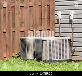 Horizontale Aufnahme von zwei älteren Klimaanlagen außerhalb des Einfamilienhauses. Stockfoto