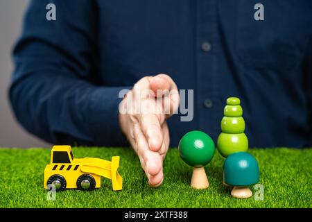 Ein Mann hält einen Bulldozer davon ab, Bäume zu Fällen. Verhindern Sie, dass der Wald abgeholzt wird. Retten Sie die Natur. Schutz von Naturschutzgebieten. Deforesta Stockfoto