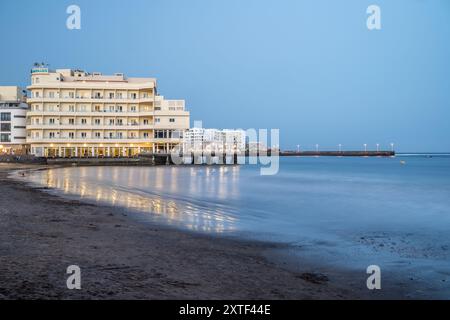 Ruhiger abendlicher Blick auf das Hotel Medano, El Medano, mit Reflexionen, in Granadilla de Abona, Teneriffa, Kanarischen Inseln. Stockfoto