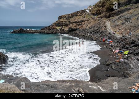 Atemberaubender Blick auf den Strand Goyuyo mit schwarzem Sand, Besuchern und blauem Meer in La Orotava, Teneriffa, Kanarischen Inseln, Spanien. Stockfoto