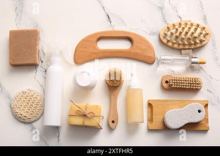 Komposition mit hölzernem guasha-Körpermassagegerät und Badeutensilien auf Marmorhintergrund Stockfoto