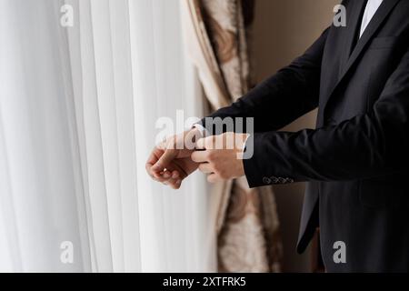 Geschäftsmann passt seine Anzugsjacke an und betont Professionalität und Liebe zum Detail im Büro Stockfoto