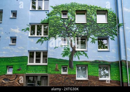 Wohnhäuser an der Feldsieper Straße in Bochum, nach einer energetischen Sanierung, mit Fassadendämmung, hat die Bochumer Wohnstätten Wohnungsgenossenschaft, die Gebäude mit einem großen Wandbild bemalen lassen, vom Dortmunder Graffiti Künstler Denis Klatt, es zeigt auf der gesamten Fassade ein Blaukehlchen und eine Landschaft mit Bäumen, Leben unter der Erde und viel Himmel, Bochum-Hamme, NRW, Deutschland, Wandbild *** Wohnhäuser an der Feldsieper Straße in Bochum, nach einer energetischen Sanierung, mit Fassadendämmung, hat die Bochumer Wohnstätten Wohnungsgenossenschaft den Bau veranlasst Stockfoto