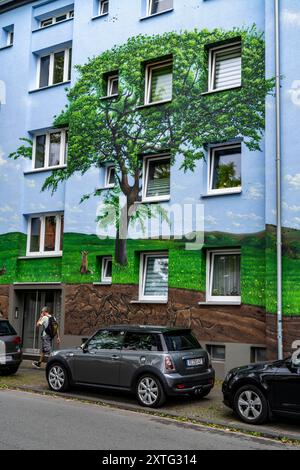 Wohnhäuser an der Feldsieper Straße in Bochum, nach einer energetischen Sanierung, mit Fassadendämmung, hat die Bochumer Wohnstätten Wohnungsgenossenschaft, die Gebäude mit einem großen Wandbild bemalen lassen, vom Dortmunder Graffiti Künstler Denis Klatt, es zeigt auf der gesamten Fassade ein Blaukehlchen und eine Landschaft mit Bäumen, Leben unter der Erde und viel Himmel, Bochum-Hamme, NRW, Deutschland, Wandbild *** Wohnhäuser an der Feldsieper Straße in Bochum, nach einer energetischen Sanierung, mit Fassadendämmung, hat die Bochumer Wohnstätten Wohnungsgenossenschaft den Bau veranlasst Stockfoto