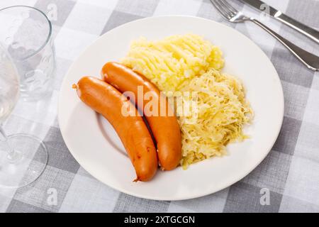 Gebratene Würstchen mit Kartoffelbrei und gedünstetem Kohl Stockfoto