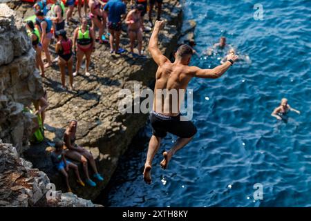 (240815) -- PULA, 15. August 2024 (Xinhua) -- Ein Mann taucht in das Meer Ein, um sich am 14. August 2024 von der Klippe am Seagull's Rocks Beach in Pula, Kroatien, abzukühlen. Die maximale Temperatur in Pula erreicht tagsüber 35 Grad Celsius. (Srecko Niketic/PIXSELL Via Xinhua) Stockfoto