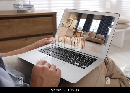 Mann sucht Haus auf der Immobilienmarkt-Website zu Hause, Nahaufnahme Stockfoto