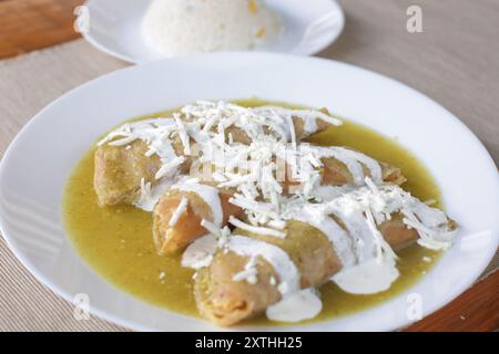 Grüne Enchiladas mit Huhn, Sahne und Käse, eine typisch mexikanische Mahlzeit Stockfoto