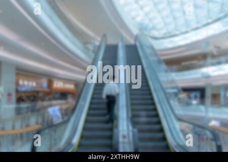 Verschwommenes Bild einer Rolltreppe in einem modernen Einkaufszentrum. Stockfoto