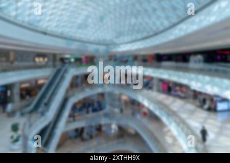 Verschwommener Blick auf ein Einkaufszentrum in Shenzhen, China, mit einer Glasdecke und Rolltreppen. Stockfoto