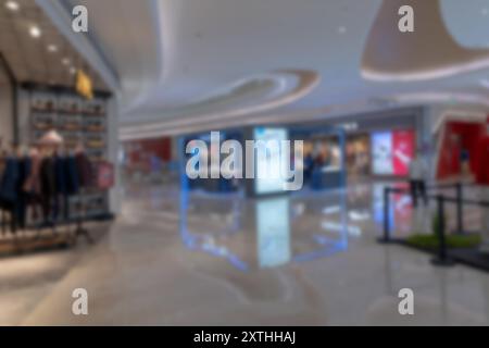 Ein verschwommenes Bild eines Einkaufszentrums mit Bokeh-Lichtern und einem großen Schild, wahrscheinlich in Shenzhen, China. Stockfoto
