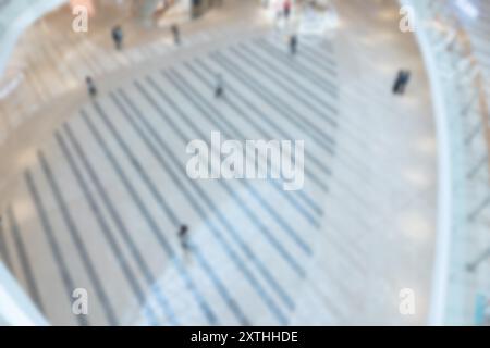 Ein verschwommener Blick auf Leute, die auf einem gefliesten Boden in einem Shenzhen Einkaufszentrum laufen. Das Bild ist unscharf und erzeugt Bokeh-Effekte. Stockfoto