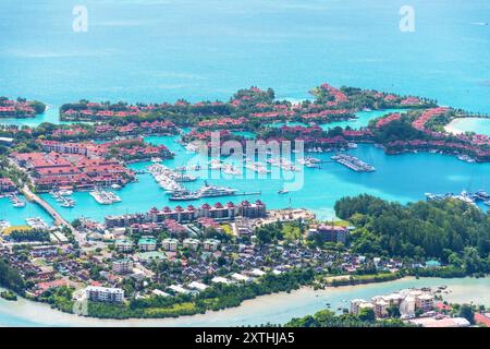 Ein atemberaubender Blick aus der Luft auf ein tropisches Inselresort mit einem wunderschönen Yachthafen voller Yachten und Boote. Seychellen - tropisches Reiseziel Stockfoto