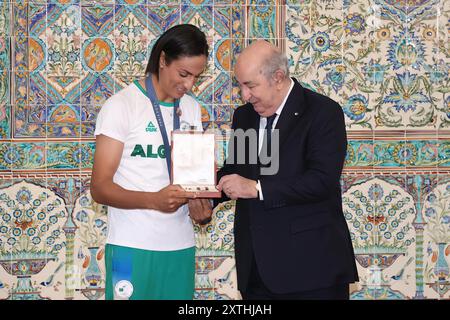 Algier, Algerien. August 2024. Der algerische Präsident Abdelmadjid Tebboune erhält Goldmedaillengewinner Imane Khelif sowie die beiden anderen Olympiasieger Djamel Sedjati und Kaylia Nemour im Mouradia Presidential Palace in Algier, Algerien am 14. August 2024. Foto: Balkis Press/ABACAPRESS. COM Credit: Abaca Press/Alamy Live News Stockfoto