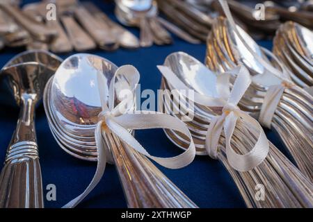 Besteck zum Verkauf im Mercatino dell'Antiquariato, dem berühmten Flohmarkt in Venedig. Silberlöffel mit cremigem Band zusammengebunden. Stockfoto