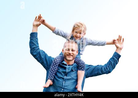 Trage auf Schultern, Himmel oder Porträt eines glücklichen Mädchens mit Vater, liebe oder Sorge für gemeinsame Entspannung für alleinerziehende Eltern. Hände halten, Natur oder Vater mit Stockfoto