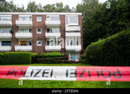 Hamburg, Deutschland. August 2024. Polizeikordonband hängt vor einem Wohnhaus im Langenhorn. Sechs Personen wurden verletzt, als am Vorabend ein Balkon fiel. (Zu dpa: 'Balkon abgestürzt: Sechs Menschen verletzt') Credit: Daniel Bockwoldt/dpa/Alamy Live News Stockfoto