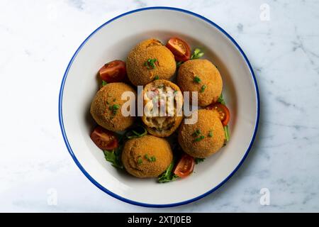 Spanische Tapa-Kroketten mit Bechamelsoße, gefüllt mit Tintenfisch und Kartoffeln. Tabelle mit Draufsicht Stockfoto