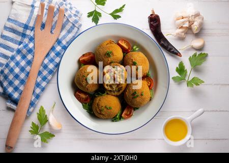 Spanische Tapa-Kroketten mit Bechamelsoße, gefüllt mit Tintenfisch und Kartoffeln. Tabelle mit Draufsicht Stockfoto