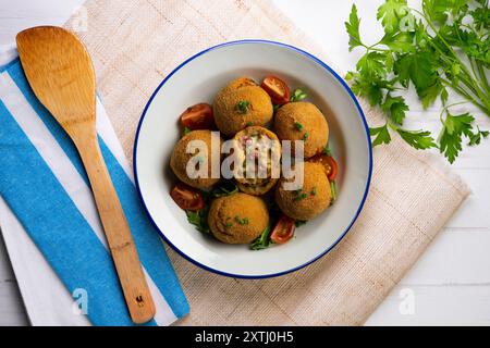 Spanische Tapa-Kroketten mit Bechamelsoße, gefüllt mit Tintenfisch und Kartoffeln. Tabelle mit Draufsicht Stockfoto