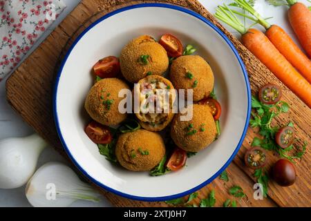 Spanische Tapa-Kroketten mit Bechamelsoße, gefüllt mit Tintenfisch und Kartoffeln. Tabelle mit Draufsicht Stockfoto