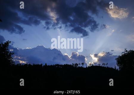 Symbolfoto. Die Sonne geht hinter einem mit Nadelbaeumen bewachsenen Berg unter. Ziegenrueck, 20.07.2024. Ziegenrueck Deutschland *** Symbolfoto Stockfoto