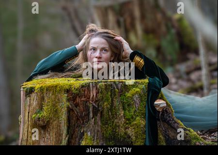 Eine Frau ist in einem Baumstumpf in einem Wald gefangen. Geringe Tiefe von feld Stockfoto