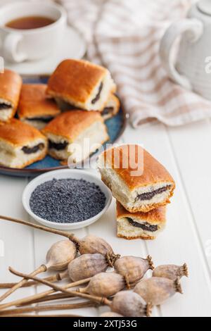 Süßes Brötchen mit Mohn auf einem weißen Tisch. Stockfoto