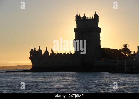 Sonnenuntergang über dem Fluss Tejo in Belém, Lissabon, Portugal, Europa. Silhouette des Torre de Belém. UNESCO-Weltkulturerbe. Stockfoto