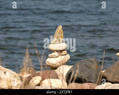 Gestapelte Steine zu Türmen und Figuren am Strand sind beliebte Fotomotive, die Touristen als Zeichen von Balance und Achtsamkeit aufhäufen. Ein Symbol o Stockfoto