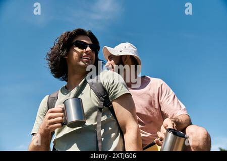 Ein junges schwules Paar macht eine Wanderung in der Wildnis an einem sonnigen Sommertag. Stockfoto