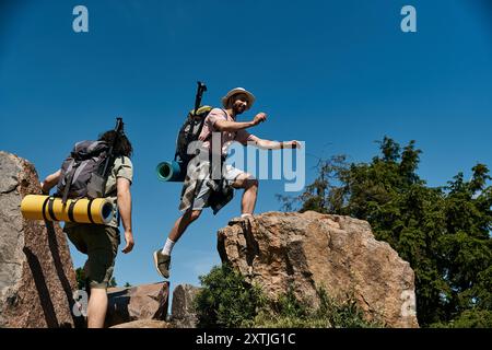 Ein junges schwules Paar wandert zusammen in der Wildnis an einem sonnigen Sommertag. Stockfoto