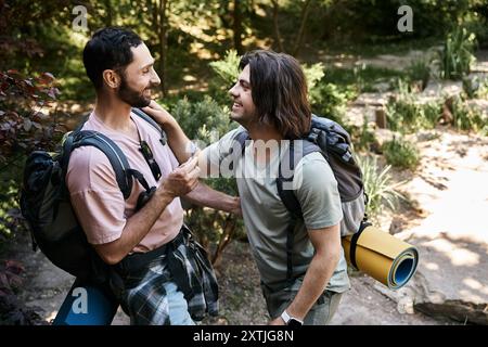 Ein junges schwules Paar wandert gemeinsam in der Sommerwildnis und genießt die wunderschöne Natur. Stockfoto