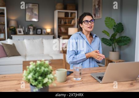 Videoanruf für Geschäftsfrau. Junge, erfolgreiche Frau, die im Home Office arbeitet und mit Kollegen über eine Laptop-Webcam spricht, virtuelle Mitarbeiterbesprechungen abhält, givi Stockfoto