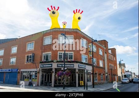 Slough, Großbritannien. August 2024. Das Stadtzentrum von Slough in Berkshire sah heute fröhlicher aus als sonst, als fünf riesige aufblasbare Dachmonster die Käufer und Besucher des Stadtzentrums begrüßten. Die Künstler Luke Egan und Peter Hamilton haben die riesigen aufblasbaren Monster auf dem Porter Building, dem Queensmere Shopping Centre, The Future Works, Aston Bond Solicitors und dem Brickhouse installiert. Monster Nosey Bonk, Bezerker, Tentakel, Brülzer und eine Familie von Goofs erweisen sich in den Schulferien als großer Hit bei Kindern. Die Monster bleiben in dir Stockfoto