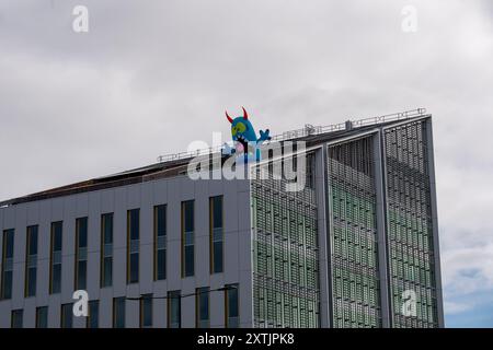 Slough, Großbritannien. August 2024. Das Stadtzentrum von Slough in Berkshire sah heute fröhlicher aus als sonst, als fünf riesige aufblasbare Dachmonster die Käufer und Besucher des Stadtzentrums begrüßten. Die Künstler Luke Egan und Peter Hamilton haben die riesigen aufblasbaren Monster auf dem Porter Building, dem Queensmere Shopping Centre, The Future Works, Aston Bond Solicitors und dem Brickhouse installiert. Monster Nosey Bonk, Bezerker, Tentakel, Brülzer und eine Familie von Goofs erweisen sich in den Schulferien als großer Hit bei Kindern. Die Monster bleiben in dir Stockfoto